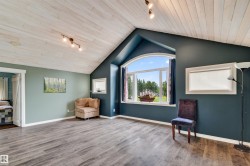 Spacious loft style room featuring vaulted wood-finish plank ceilings, track lighting, and wood-finish flooring - 