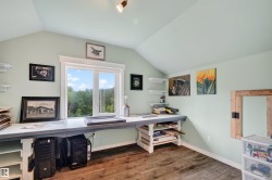 Sloped ceiling upstairs bedroom featuring a double window, wood-finish flooring, light green painted walls and track lighting - 