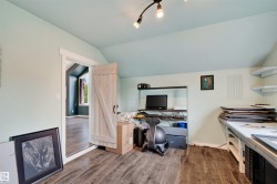 Upstairs bedroom featuring wood-finish flooring and a light-colored barn door - 