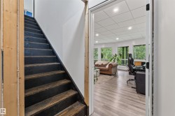 Staircase with dark-stained wood treads and white risers, framed by light wood trim - 
