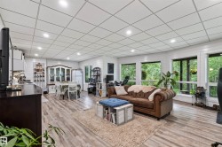 Open-concept Basement living space featuring wood-finish flooring, recessed lighting, and white shiplap walls - 