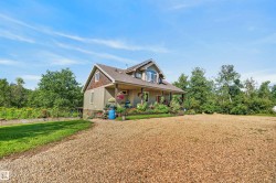 Multi-level residence featuring a dormer window, covered porch, and a gravel driveway - 