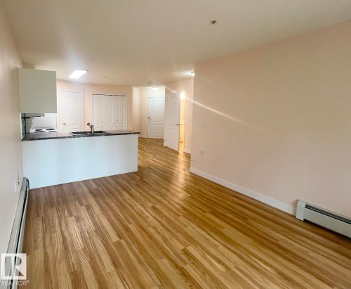 Open-concept living space featuring wood-finish flooring - #147 13441 127 St Nw, Edmonton, AB 