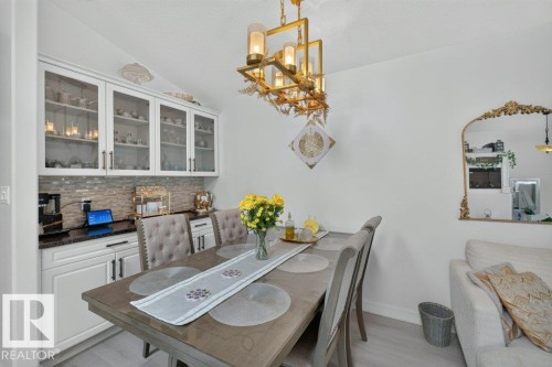 Recessed built-in cabinetry with glass-front upper cabinets and a tile backsplash - 12219 89 Street Nw, Edmonton, AB - Indoor Photo Showing Dining Room