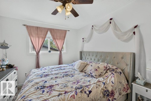 Bedroom featuring a ceiling fan, a window with natural light, and light-colored walls - 12219 89 Street Nw, Edmonton, AB - Indoor Photo Showing Bedroom
