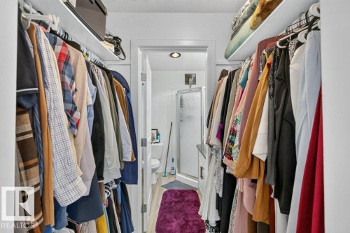 Walk-in closet featuring extensive hanging storage with upper shelving - 12219 89 Street Nw, Edmonton, AB - Indoor With Storage