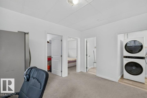 Carpeted room featuring a ceiling-mounted light fixture and multiple doorways - 12219 89 Street Nw, Edmonton, AB - Indoor