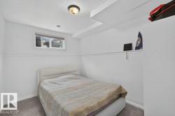 Room featuring white walls with a chair rail, a drop ceiling with recessed lighting, and grey carpet flooring - 