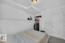 White paneled door with brushed nickel hardware, gray carpet flooring, and a ceiling-mounted light fixture - 