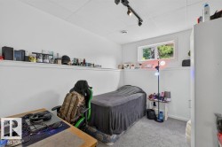 Carpeted room with a drop ceiling, track lighting, and a horizontal window - 