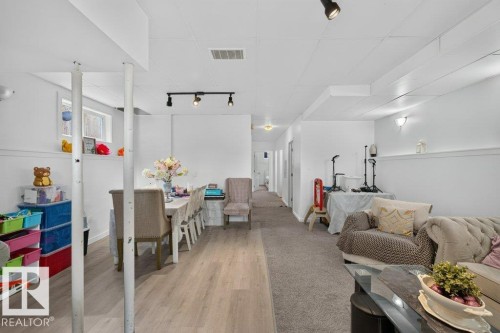 Spacious room featuring wood-finish flooring and neutral carpeting - 12219 89 Street Nw, Edmonton, AB - Indoor Photo Showing Other Room
