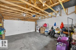 Spacious garage with exposed wood rafters and concrete flooring - 