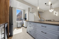 Kitchen featuring a large island with gray cabinetry and dark countertops - 