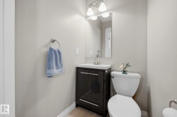 Powder room featuring a dark wood-finish vanity with a white countertop and rectangular sink - 