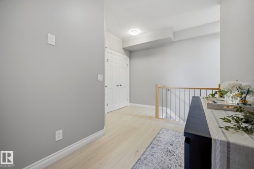 Bright upper-level hallway featuring light wood-finish flooring, soft recessed ceiling lighting, and clean white walls with crisp trim detail - #201 10625 Kingsway Av Nw, Edmonton, AB - Indoor Photo Showing Other Room