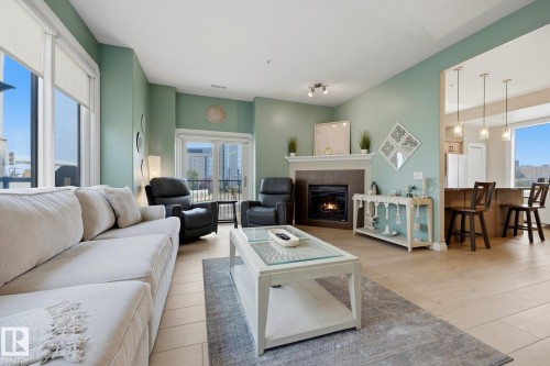Living room featuring light wood-finish flooring and a fireplace with a mantel - #201 10625 Kingsway Av Nw, Edmonton, AB - Indoor Photo Showing Living Room With Fireplace