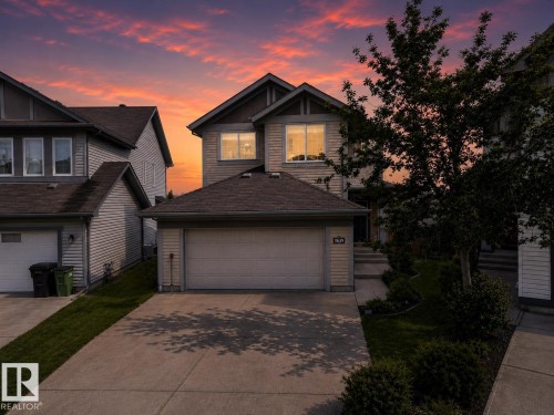 Two-story residence featuring light-toned siding, dark roof shingles, and a two-car garage with a concrete driveway - 3639 15A Street Nw, Edmonton, AB - Outdoor