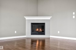 Corner fireplace with a white mantel, light gray tile surround, and black firebox - 