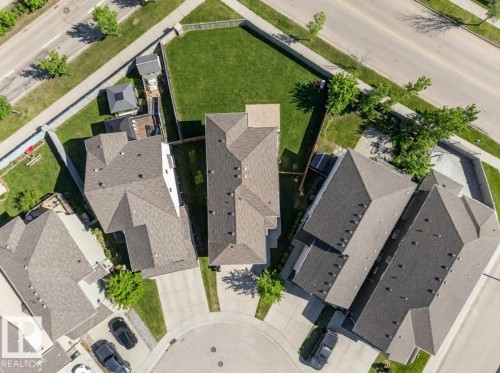 Aerial perspective showcasing a residential property with a shingle roof and a spacious, fenced backyard featuring a manicured lawn - 3639 15A Street Nw, Edmonton, AB - Outdoor With View