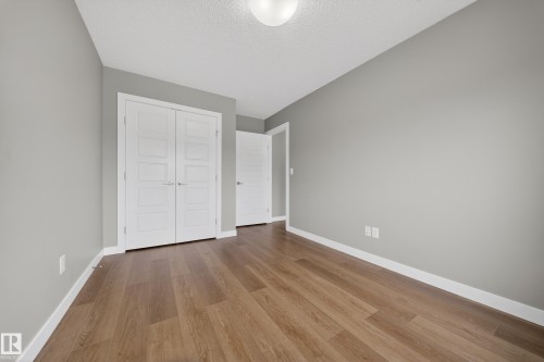 Room featuring wood-finish flooring, light gray wall paint, and crisp white baseboards - 3639 15A Street Nw, Edmonton, AB - Indoor Photo Showing Other Room