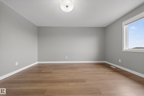 Open room featuring wood-finish flooring, light gray walls, and white baseboards - 3639 15A Street Nw, Edmonton, AB - Indoor Photo Showing Other Room