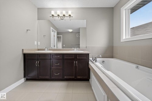 Bathroom featuring a double vanity with dark wood cabinetry and integrated sinks - 3639 15A Street Nw, Edmonton, AB - Indoor Photo Showing Bathroom