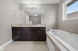 Bathroom featuring a double vanity with dark wood cabinetry and integrated sinks - 
