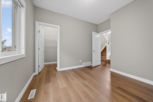 Room featuring wood-finish flooring, light grey painted walls, white trim, and a window with white framing - 3639 15A Street Nw, Edmonton, AB - Indoor Photo Showing Other Room