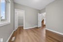 Room featuring wood-finish flooring, light grey painted walls, white trim, and a window with white framing - 3639 15A Street Nw, Edmonton, AB  - Indoor Photo Showing Other Room 