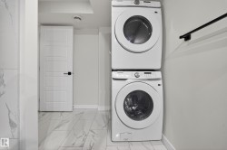 Dedicated laundry area featuring a stacked washer and dryer unit - 
