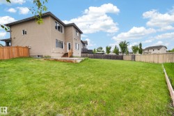 Expansive grassy yard with a multi-level wood deck and stairs - 