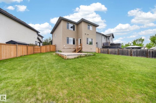 Expansive backyard featuring a manicured lawn, a raised wooden deck, and a wooden privacy fence - 3639 15A Street Nw, Edmonton, AB - Outdoor
