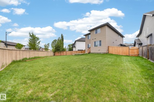 Expansive green lawn with a full wood fence perimeter - 3639 15A Street Nw, Edmonton, AB - Outdoor With Backyard