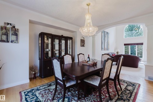 Hardwood flooring extending from the dining area into the open-concept living space - 928 Heacock Road Nw, Edmonton, AB - Indoor Photo Showing Dining Room