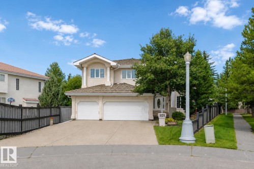 Two-story stucco residence featuring a dual garage, pitched roof, and mature front landscaping - 928 Heacock Road Nw, Edmonton, AB - Outdoor