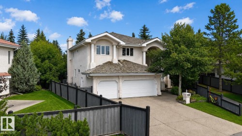Stucco exterior property featuring an attached two-car garage, concrete driveway, and mature landscaping - 928 Heacock Road Nw, Edmonton, AB - Outdoor