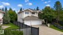 Stucco exterior property featuring an attached two-car garage, concrete driveway, and mature landscaping - 928 Heacock Road Nw, Edmonton, AB  - Outdoor 