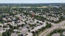 Aerial perspective of a residential neighborhood featuring established homes with varying architectural styles, mature trees, and paved streets - 928 Heacock Road Nw, Edmonton, AB  - Outdoor With View 
