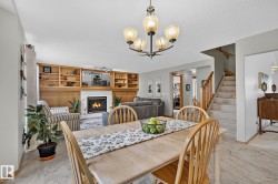 Open-concept living area featuring a built-in wood-finish shelving unit, and natural gas fireplace - 