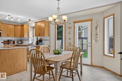 Dining area featuring a classic chandelier and light-coloured vinyl plank flooring - 