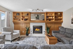 Built-in oak cabinetry with open shelving and closed storage flanks a gas fireplace - 