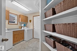 Garage entry includes the laundry room featuring wood cabinetry, a laminate countertop, and a window for natural light - 