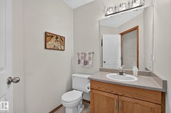 Guest bathroom on the main floor with vanity, light wood-finish cabinetry, and an integrated white basin - 