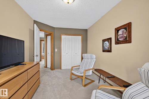 Bedroom 3 is a carpeted room featuring a ceiling-mounted light fixture, white bi-fold closet doors, and wood-finish door frames - 385 Meadowview Terrace, Sherwood Park, AB - Indoor Photo Showing Other Room