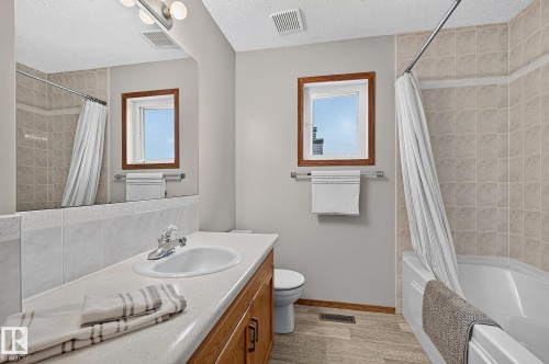 Main upstairs bathroom vanity with integrated sink, chrome faucet, and wood-finish cabinetry - 385 Meadowview Terrace, Sherwood Park, AB - Indoor Photo Showing Bathroom