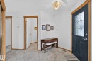 Entryway featuring a dark paneled door with decorative glass inserts, natural wood trim, a decorative ceiling light fixture, and marble-look flooring - 385 Meadowview Terrace, Sherwood Park, AB  - Indoor Photo Showing Other Room 