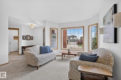 Bright living area featuring a bay window with wood trim - 