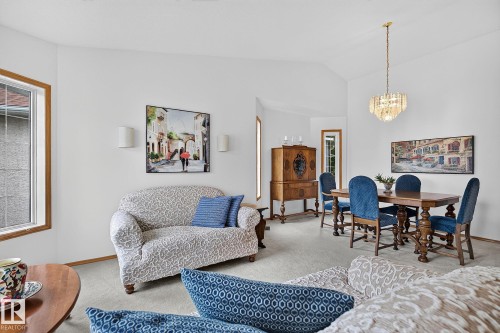 Vaulted ceilings enhance the living space, featuring a living room and dining area with a chandelier and carpeted floors - 385 Meadowview Terrace, Sherwood Park, AB - Indoor Photo Showing Living Room
