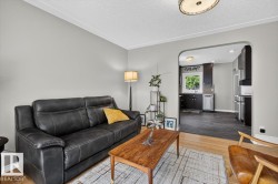 Living area featuring light wood-finish flooring, light gray wall paint, and white crown molding - 