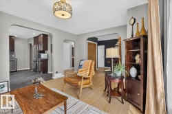 Open concept living area featuring light wood-finish flooring and arched doorways - 